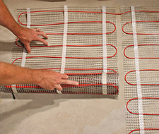 Installing the floor heating mat.